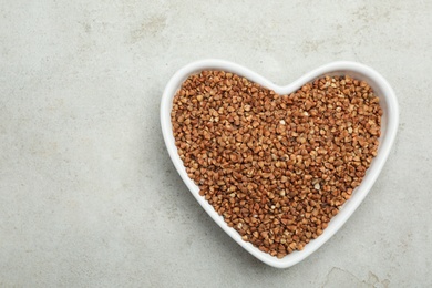 Photo of Buckwheat grains on grey table, top view. Space for text