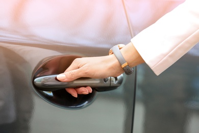Closeup view of woman opening car door