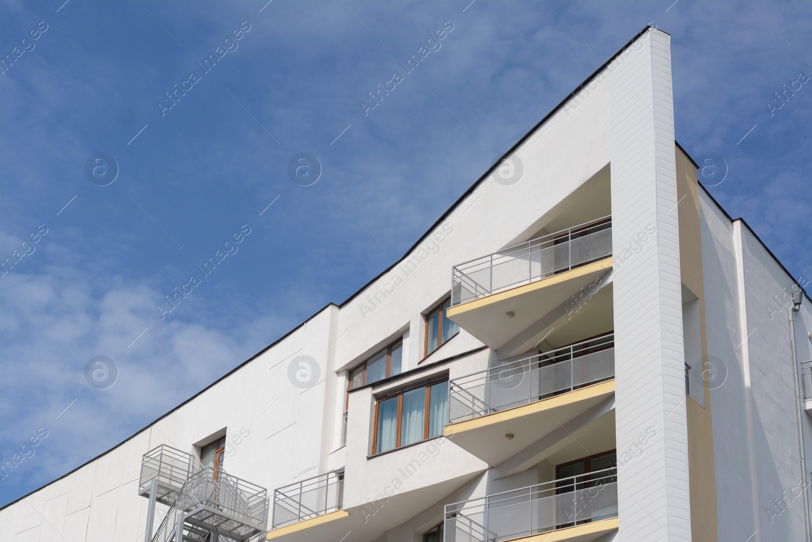 Photo of Exterior of beautiful building with balconies against blue sky, space for text