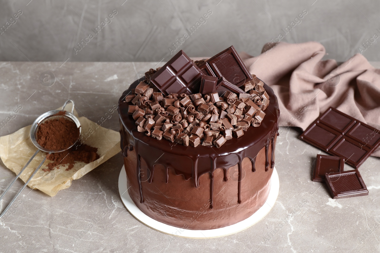 Photo of Freshly made delicious chocolate cake on marble table against grey background