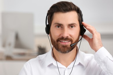 Hotline operator with headset working in office