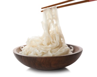 Photo of Taking rice noodles with chopsticks from bowl on white background