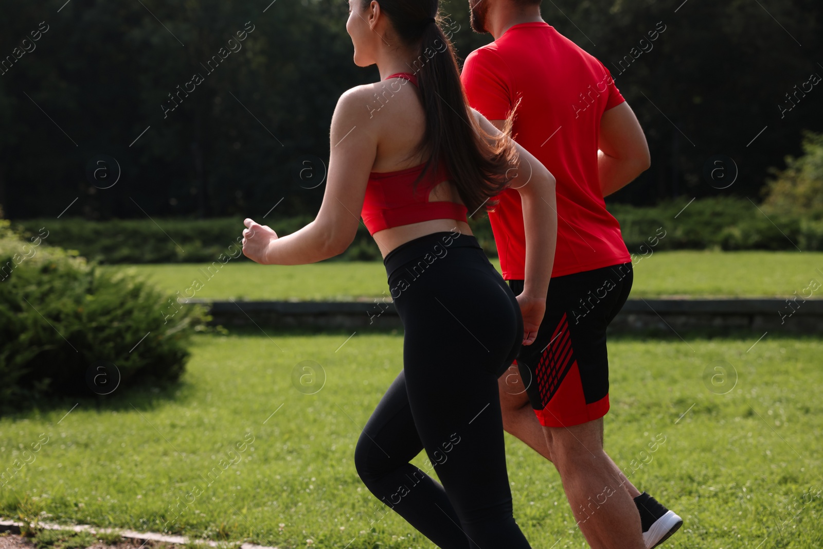 Photo of Healthy lifestyle. Couple running in park on sunny day, closeup