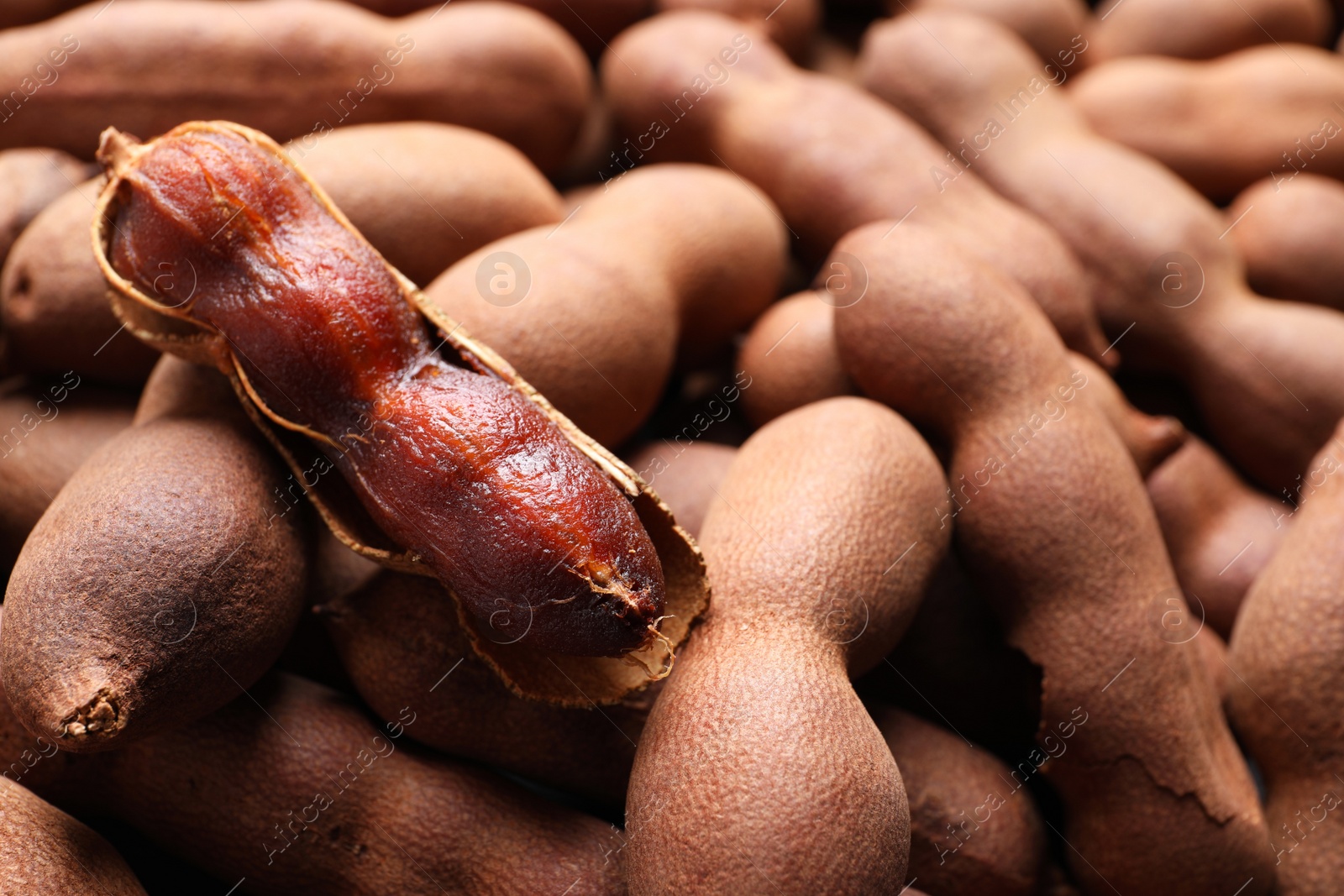 Photo of Delicious ripe tamarinds as background, closeup. Exotic fruit