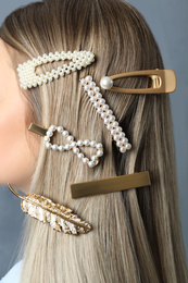 Young woman with beautiful hair clips on blue background, closeup