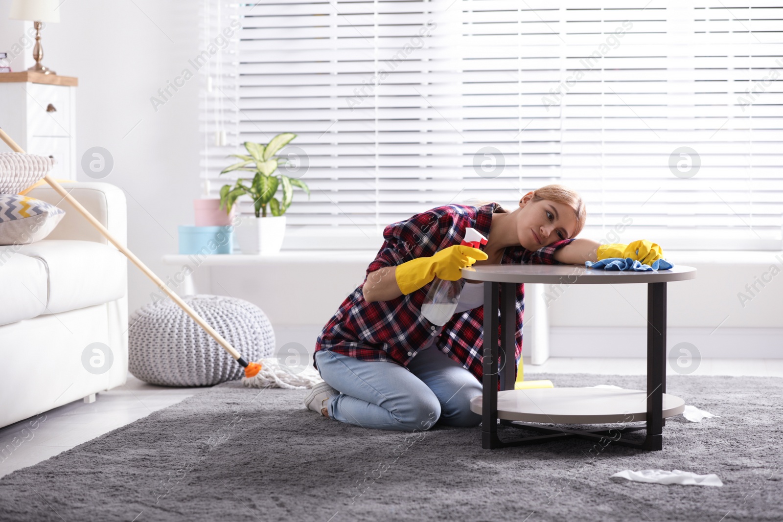 Photo of Lazy young woman wiping table at home. Cleaning and housework