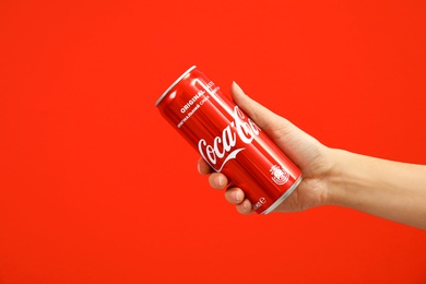 MYKOLAIV, UKRAINE - NOVEMBER 14, 2018: Woman holding Coca-Cola can on color background