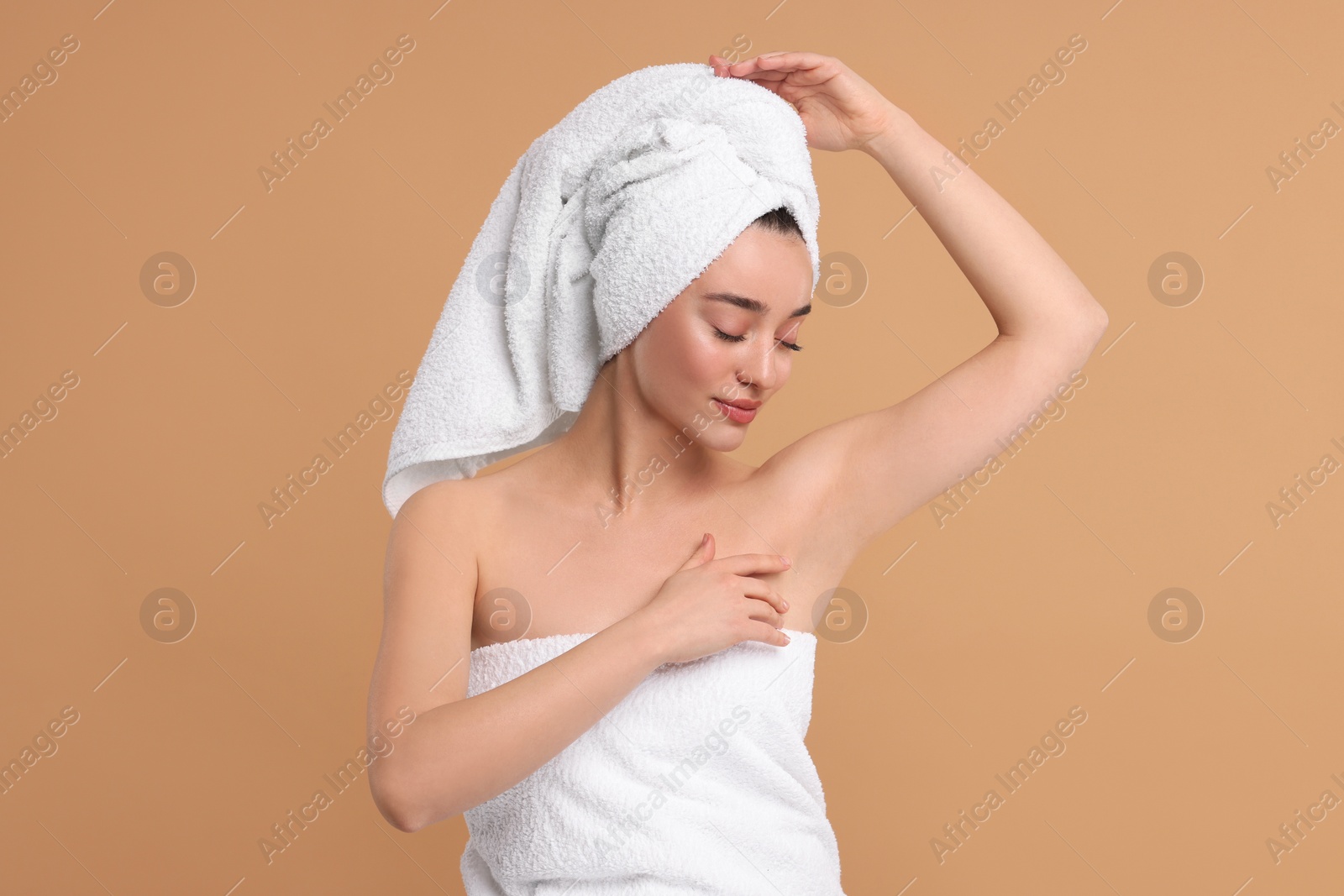 Photo of Beautiful woman showing armpit with smooth clean skin on beige background