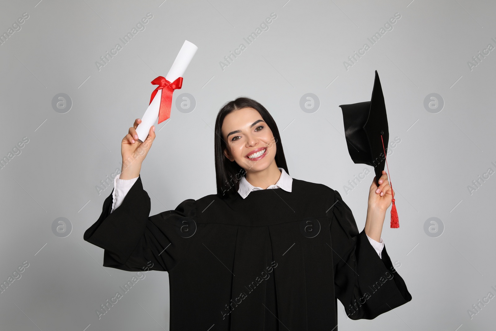 Photo of Happy student with graduation hat and diploma on grey background