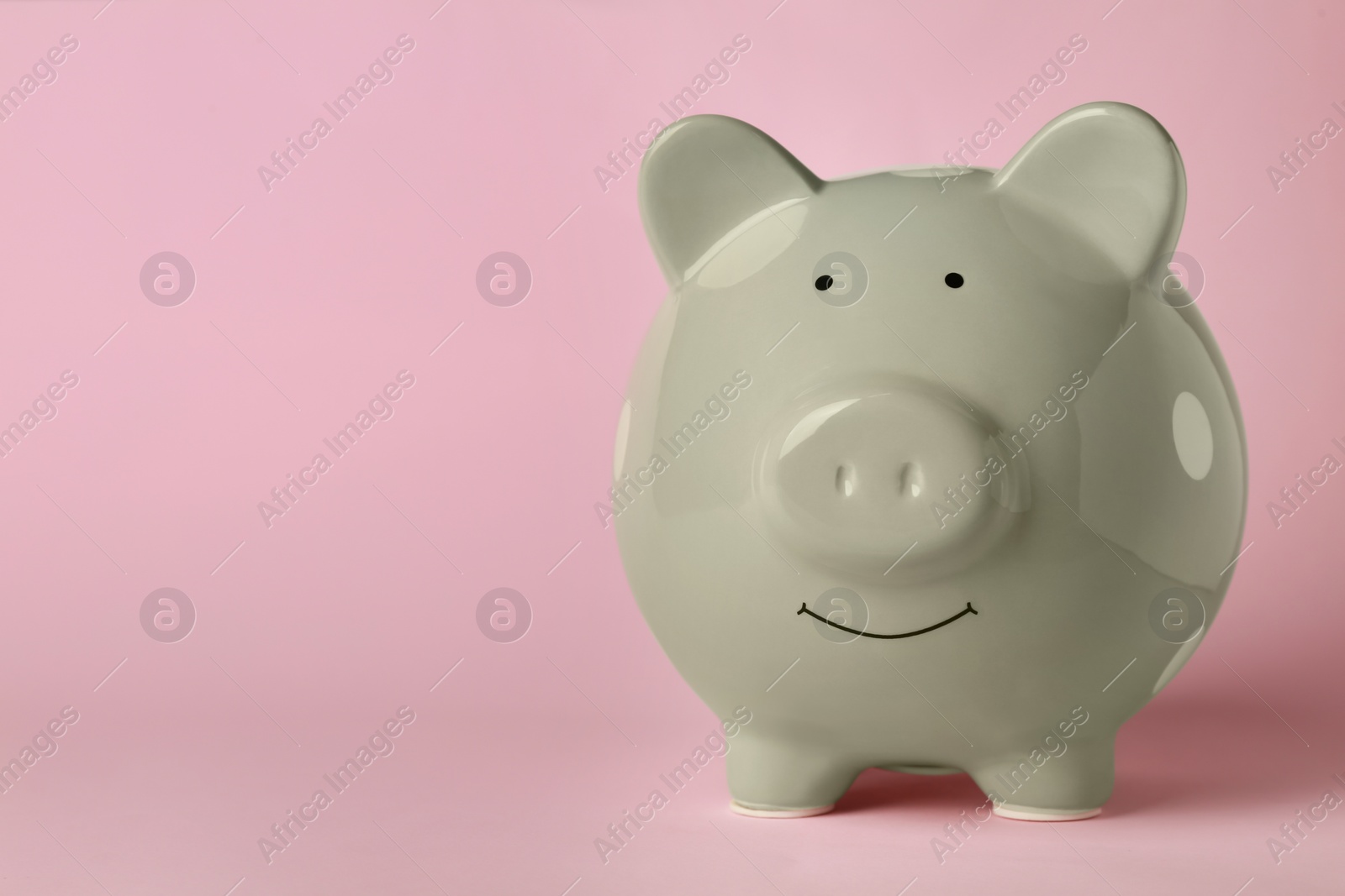 Photo of Ceramic piggy bank on pink background. Space for text