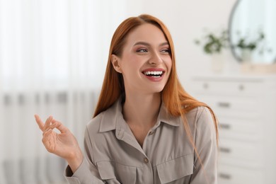 Photo of Portrait of beautiful smiling young woman. Happy lady with red hair at home