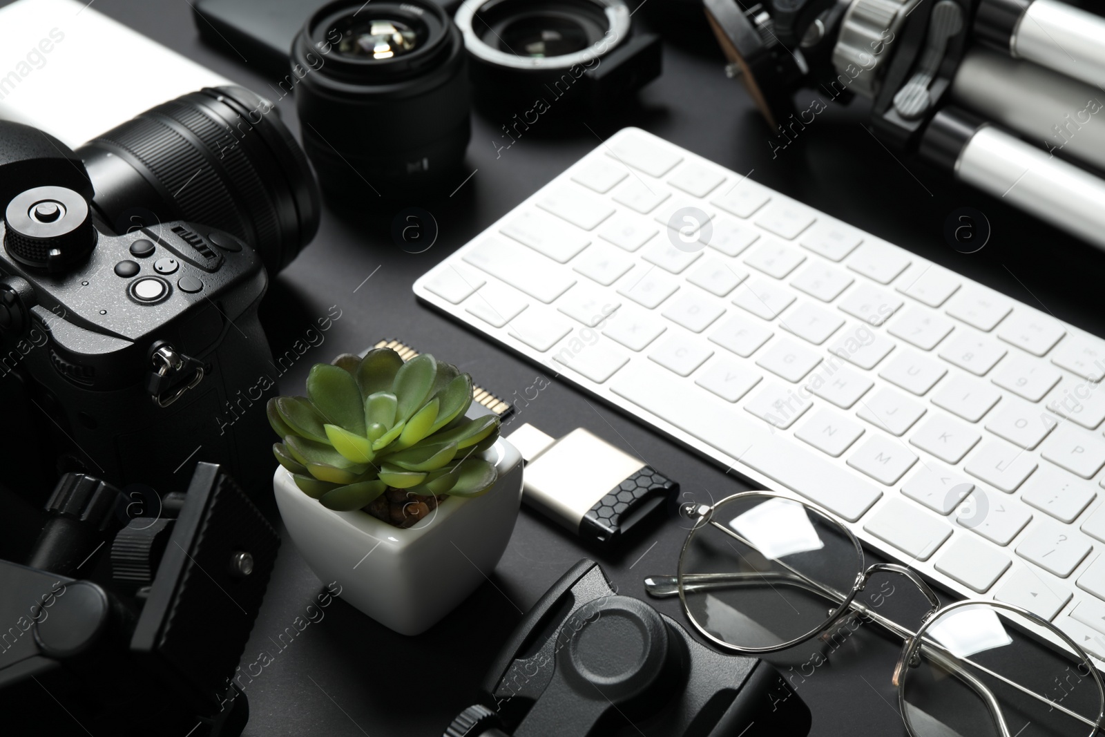 Photo of Camera, computer keyboard and video production equipment on black background