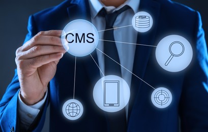 Image of CMS. Man using virtual screen, closeup. Scheme with icons on dark background