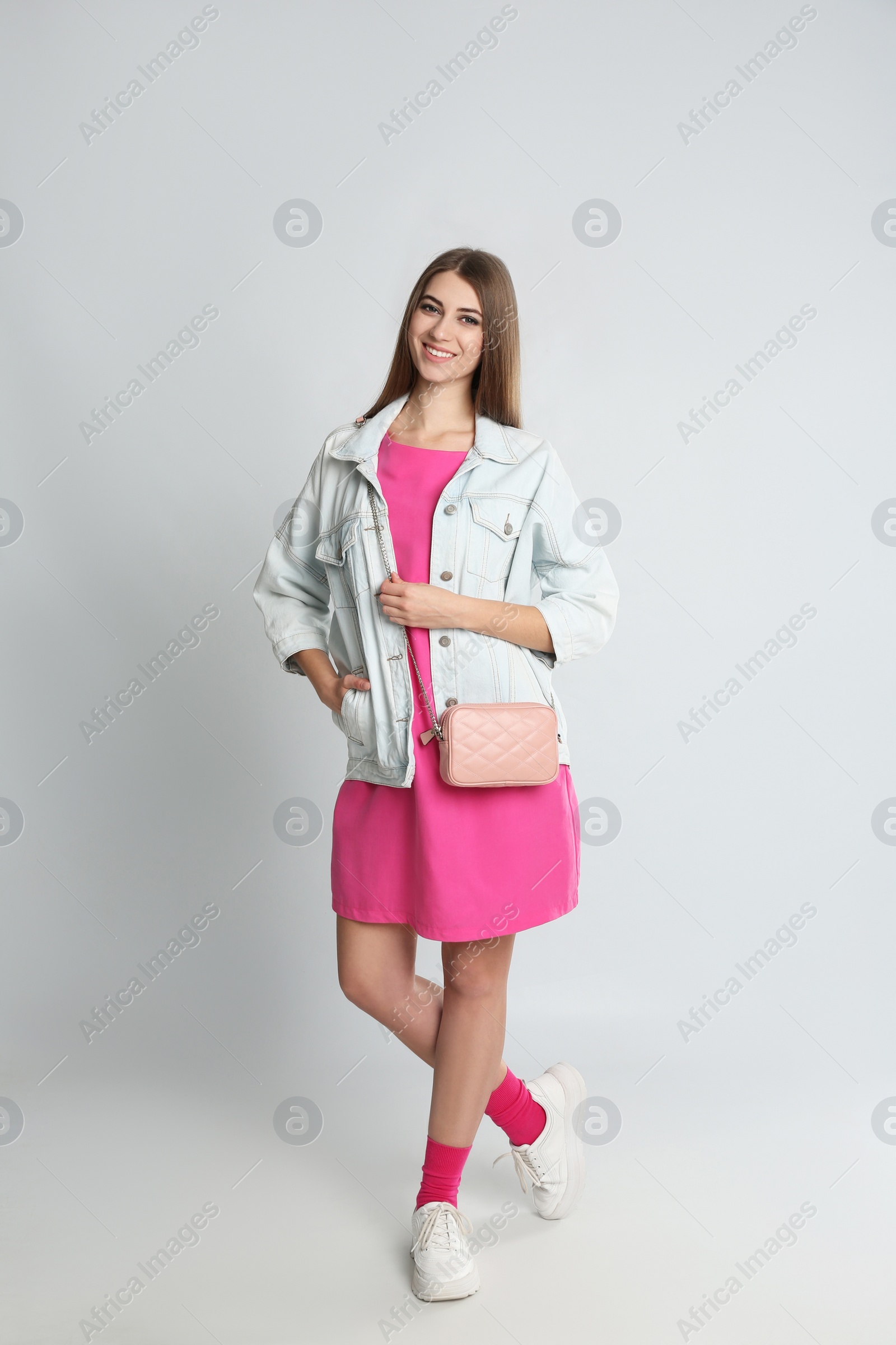 Photo of Beautiful young woman with stylish bag on grey background