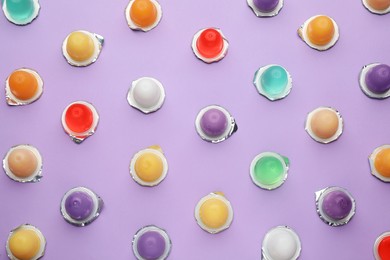 Photo of Tasty bright jelly cups on violet background, flat lay