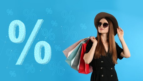 Image of Discount offer, banner design. Beautiful woman with shopping bags on light blue background. Percent signs near her