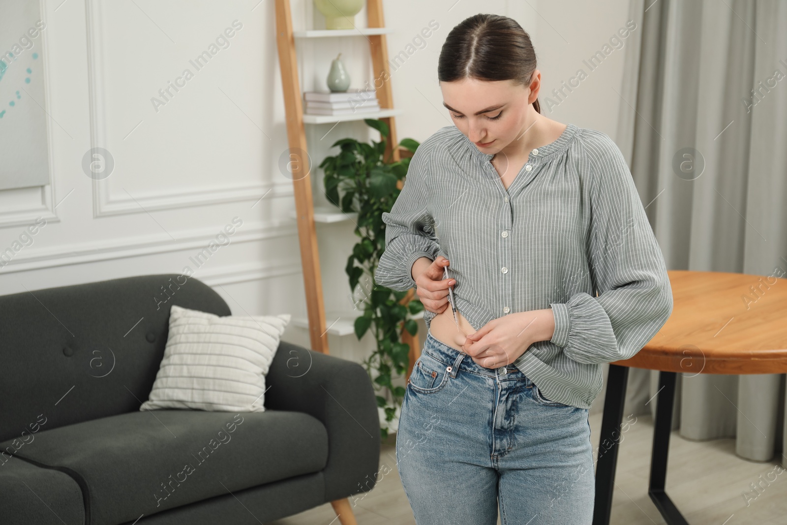 Photo of Diabetes. Woman making insulin injection into her belly at home