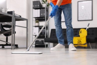 Photo of Cleaning service. Man washing floor with mop, closeup
