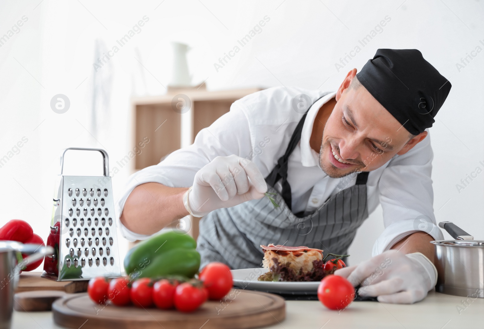 Photo of Professional chef presenting dish on table in kitchen
