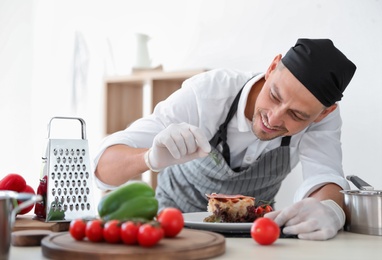Professional chef presenting dish on table in kitchen