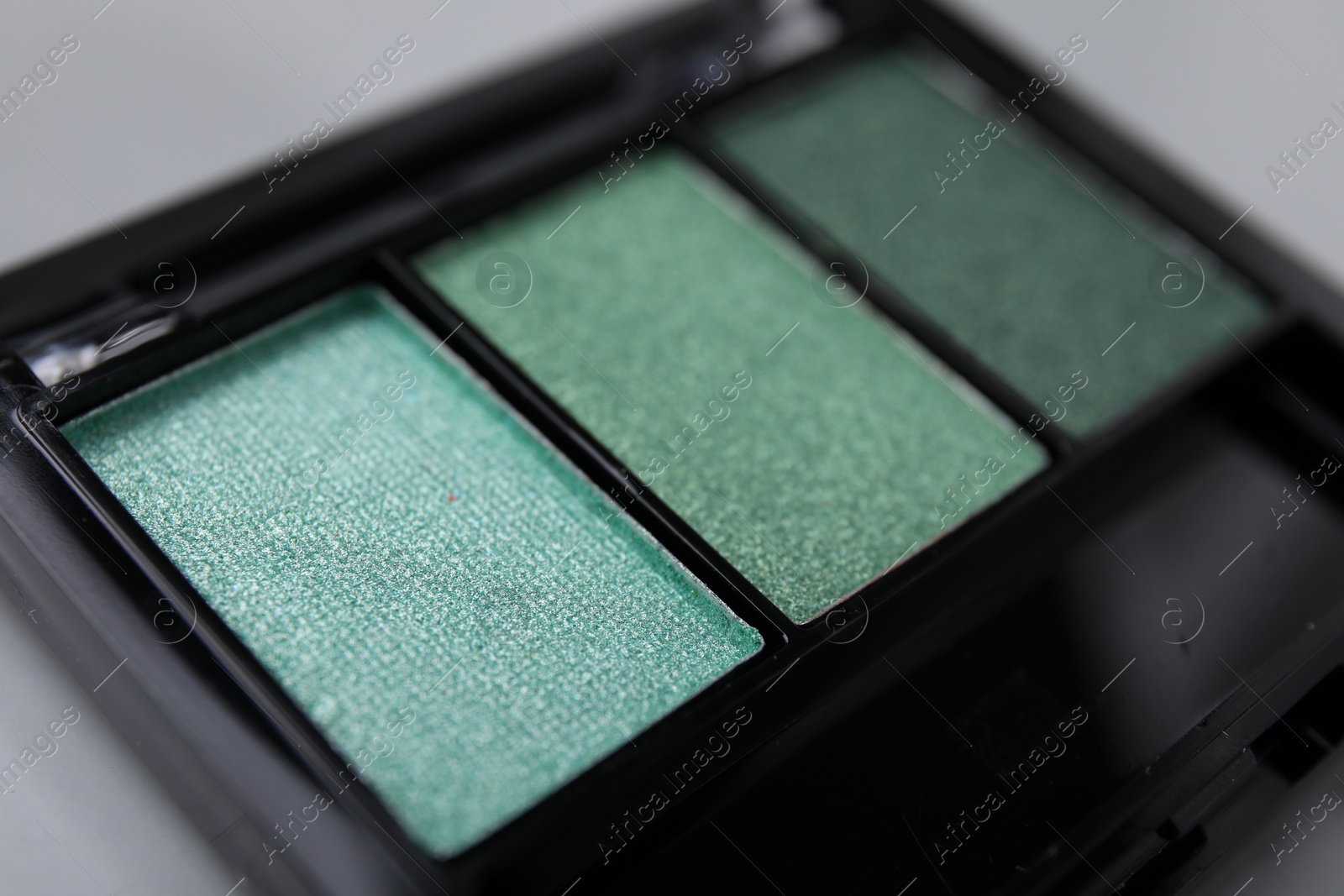 Photo of Beautiful eyeshadow palette on light gray background, closeup. Professional cosmetic product