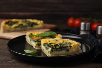 Photo of Pieces of delicious pie with spinach on wooden table, closeup