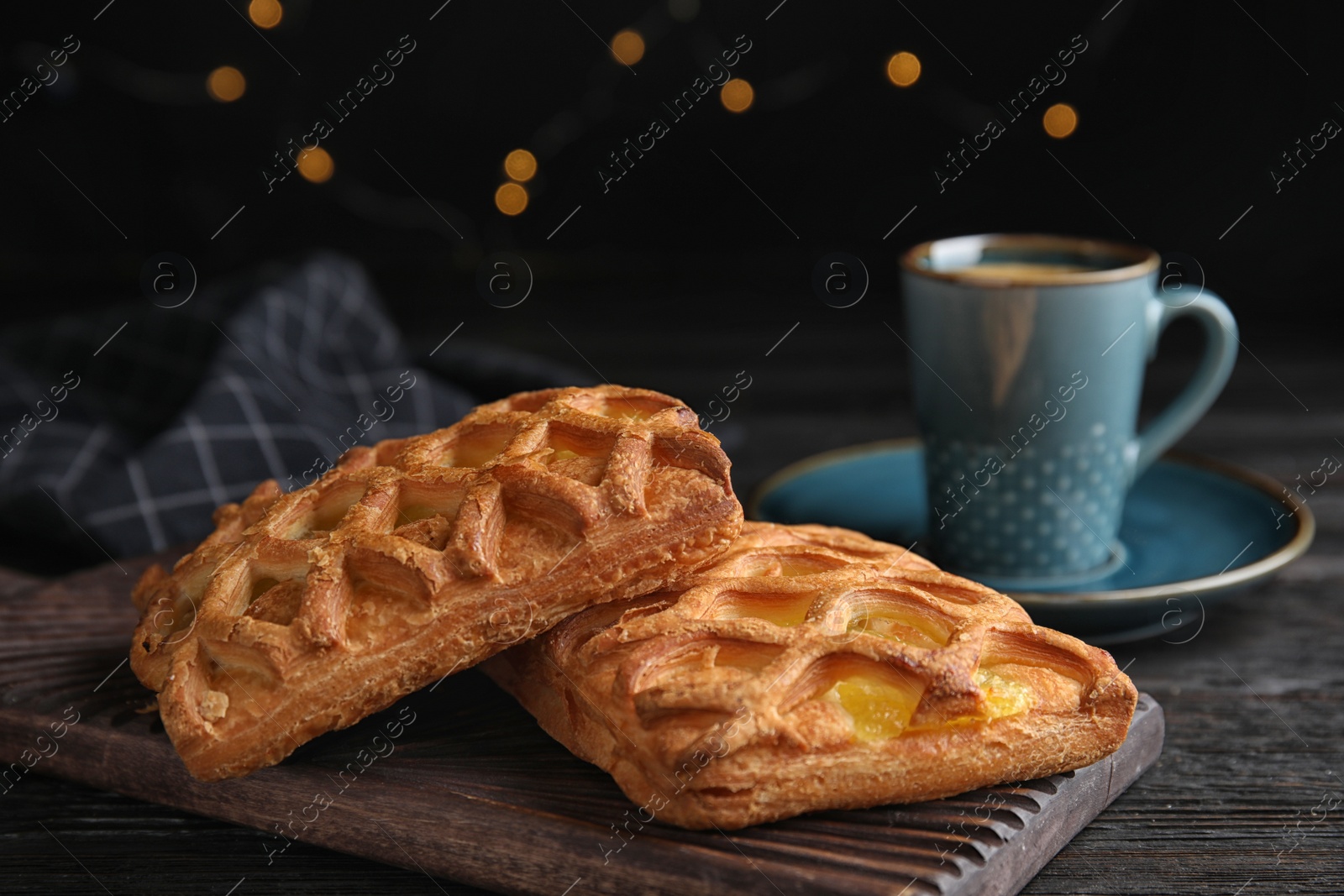 Photo of Delicious pastries and coffee on black wooden table