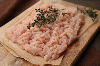 Photo of Fresh raw minced meat and thyme on table, closeup
