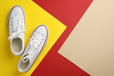 Photo of Stylish sneakers on color background, flat lay. Space for text