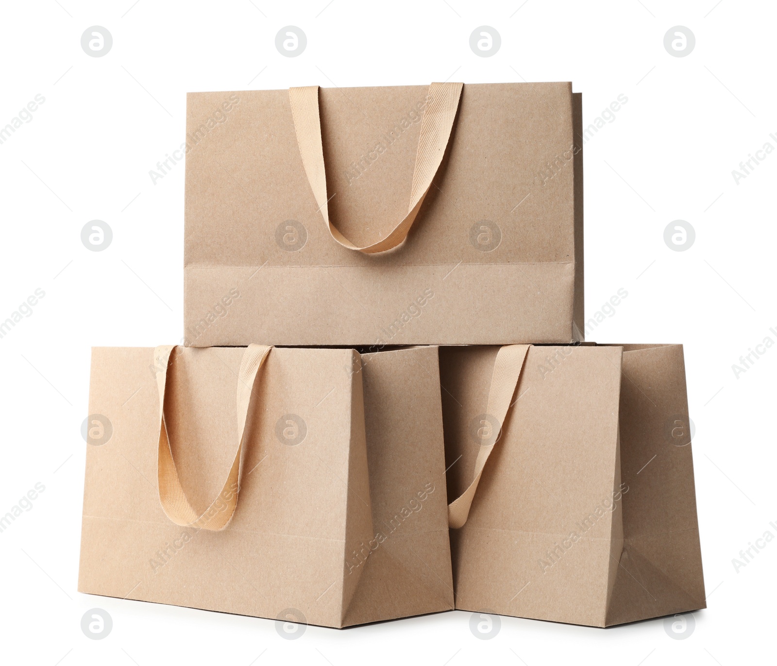 Photo of Paper shopping bags with comfortable handles on white background. Mockup for design