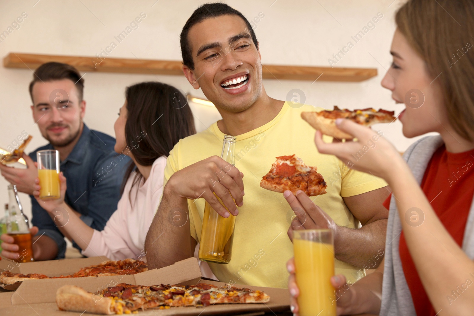 Photo of Group of friends having fun party with delicious pizza in cafe