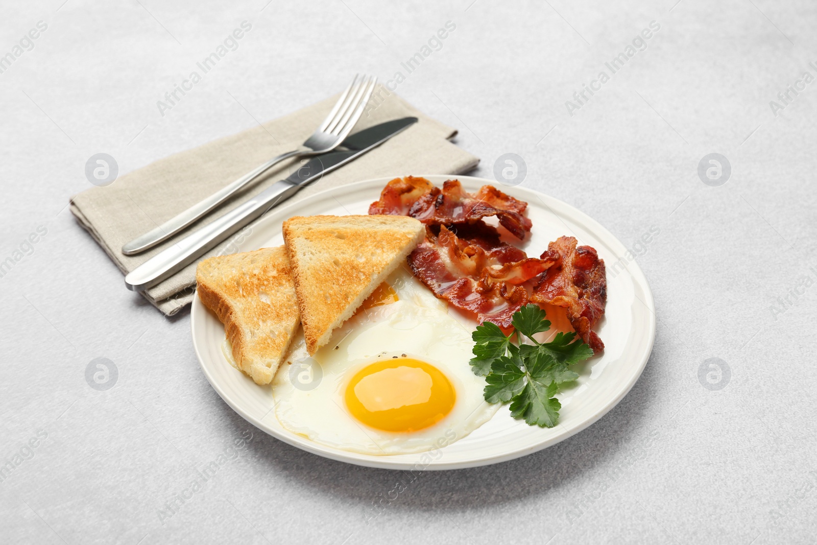 Photo of Delicious breakfast with sunny side up egg served on light table