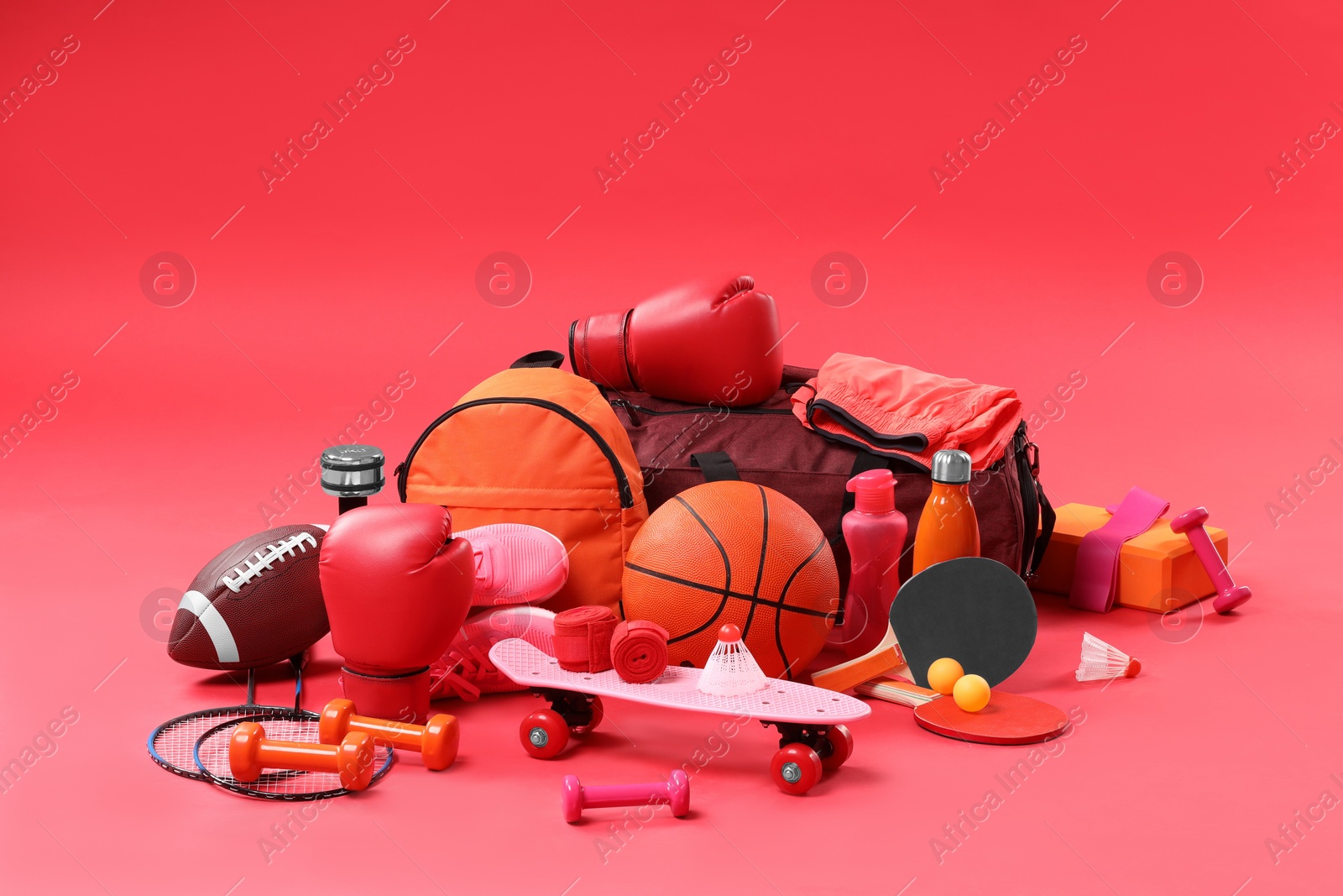 Photo of Many different sports equipment on red background