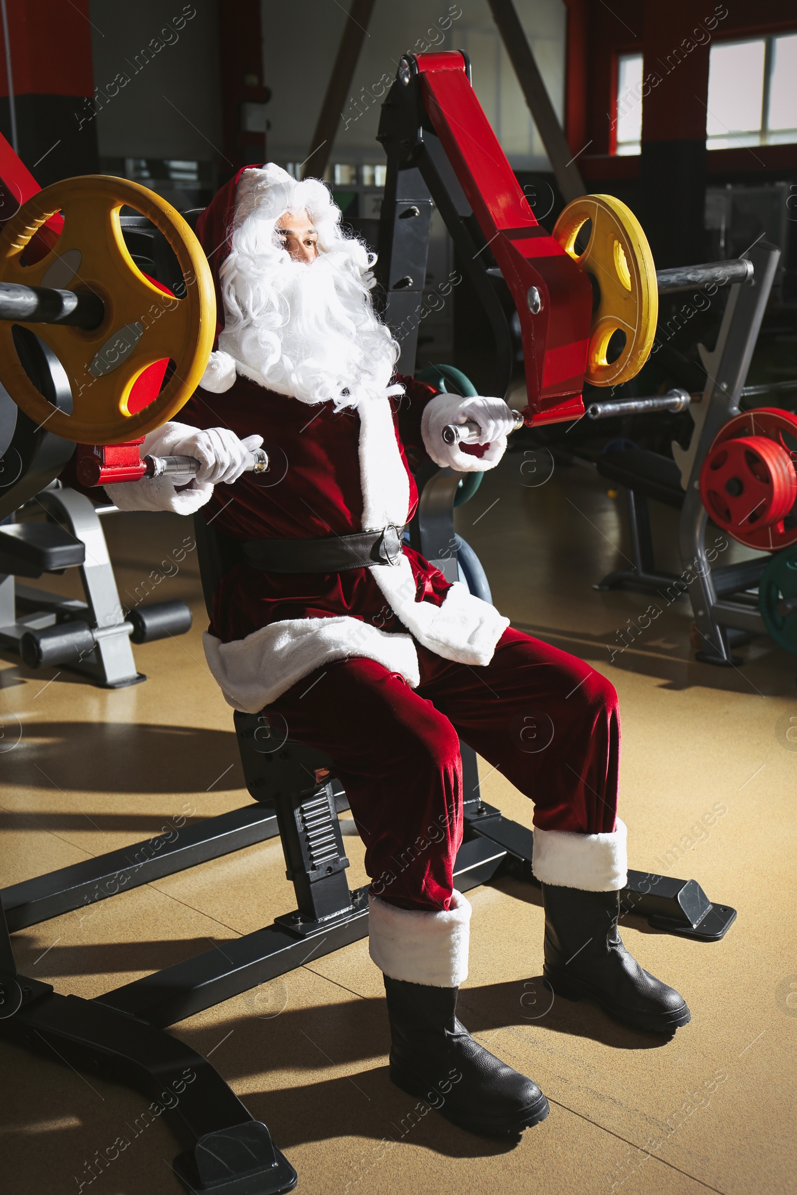 Photo of Young Santa Claus training in modern gym