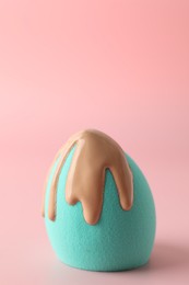 Photo of Makeup sponge with skin foundation on pink background