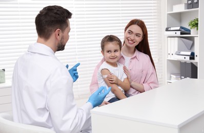 Children's hepatitis vaccination. Mother with her daughter and doctor in clinic