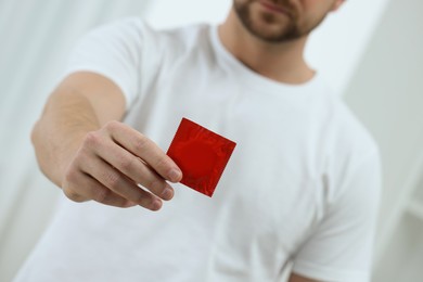 Photo of Closeup view of man showing pack with condom