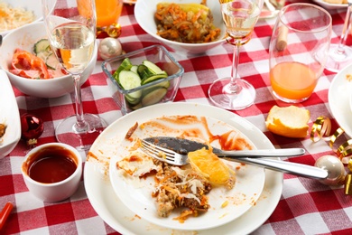 Photo of Food leftovers after party on table with checkered cloth