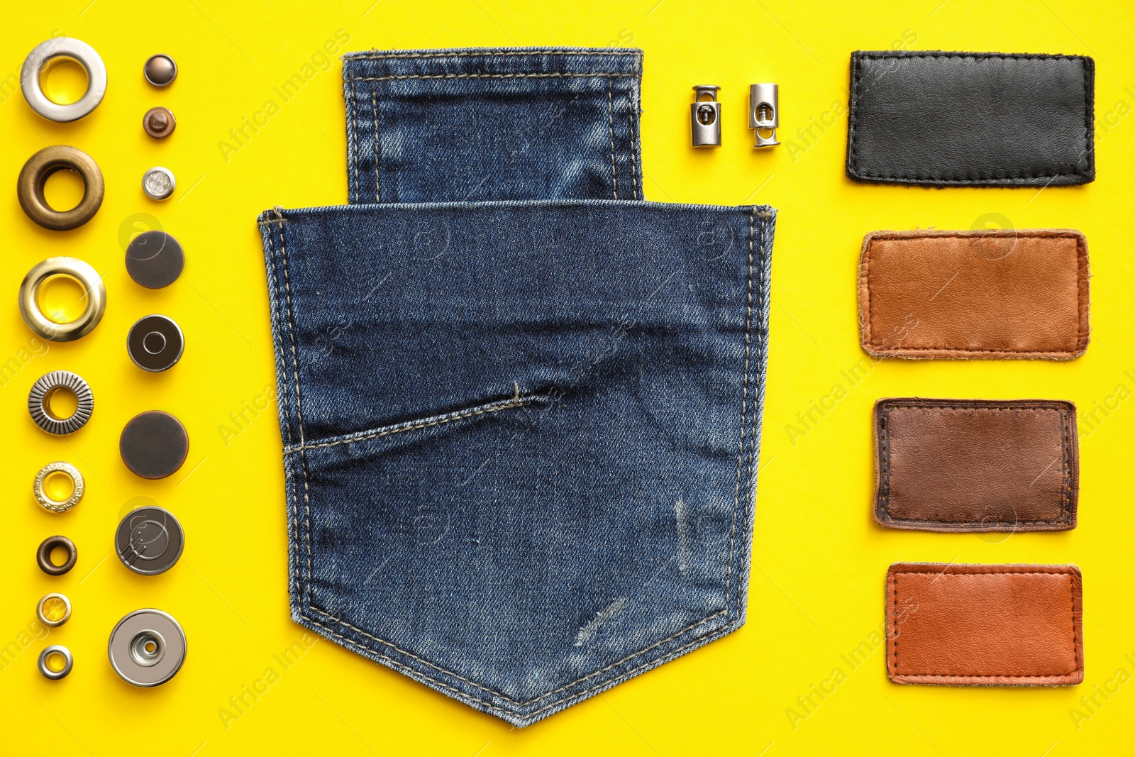 Photo of Flat lay composition with garment accessories and cutting details for jeans on yellow background