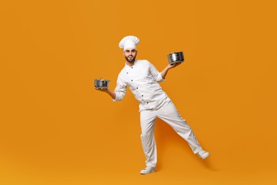 Professional chef with cooking pots on yellow background. Space for text