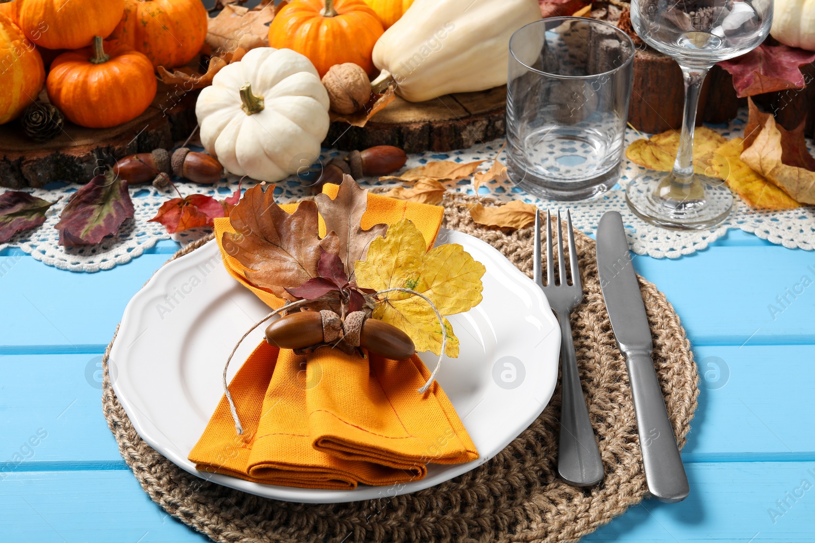 Photo of Happy Thanksgiving day. Beautiful table setting with autumn decor on light blue wooden background