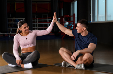 Photo of Couple after workout sitting on mats in gym