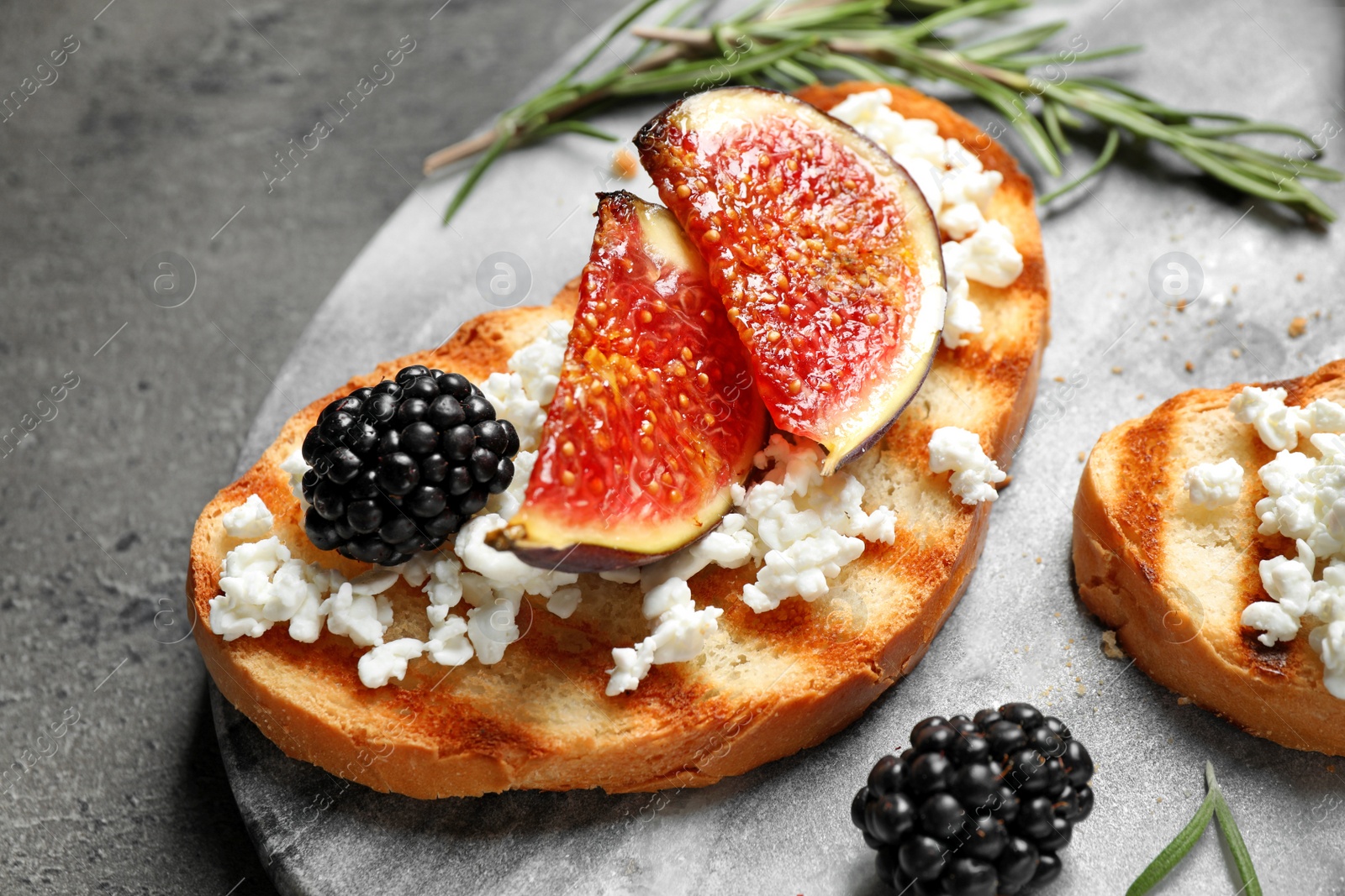 Photo of Bruschetta with ripe figs and cheese served on board, closeup