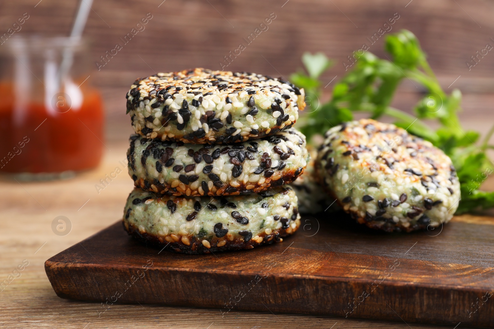 Photo of Delicious vegan cutlets with sesame on wooden table, closeup