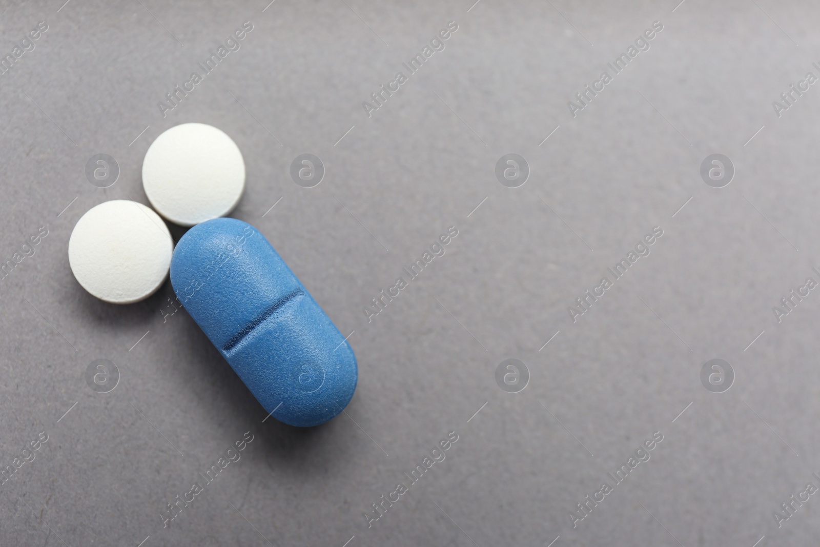Photo of Composition of pills symbolizing potency problems on grey background, flat lay. Space for text