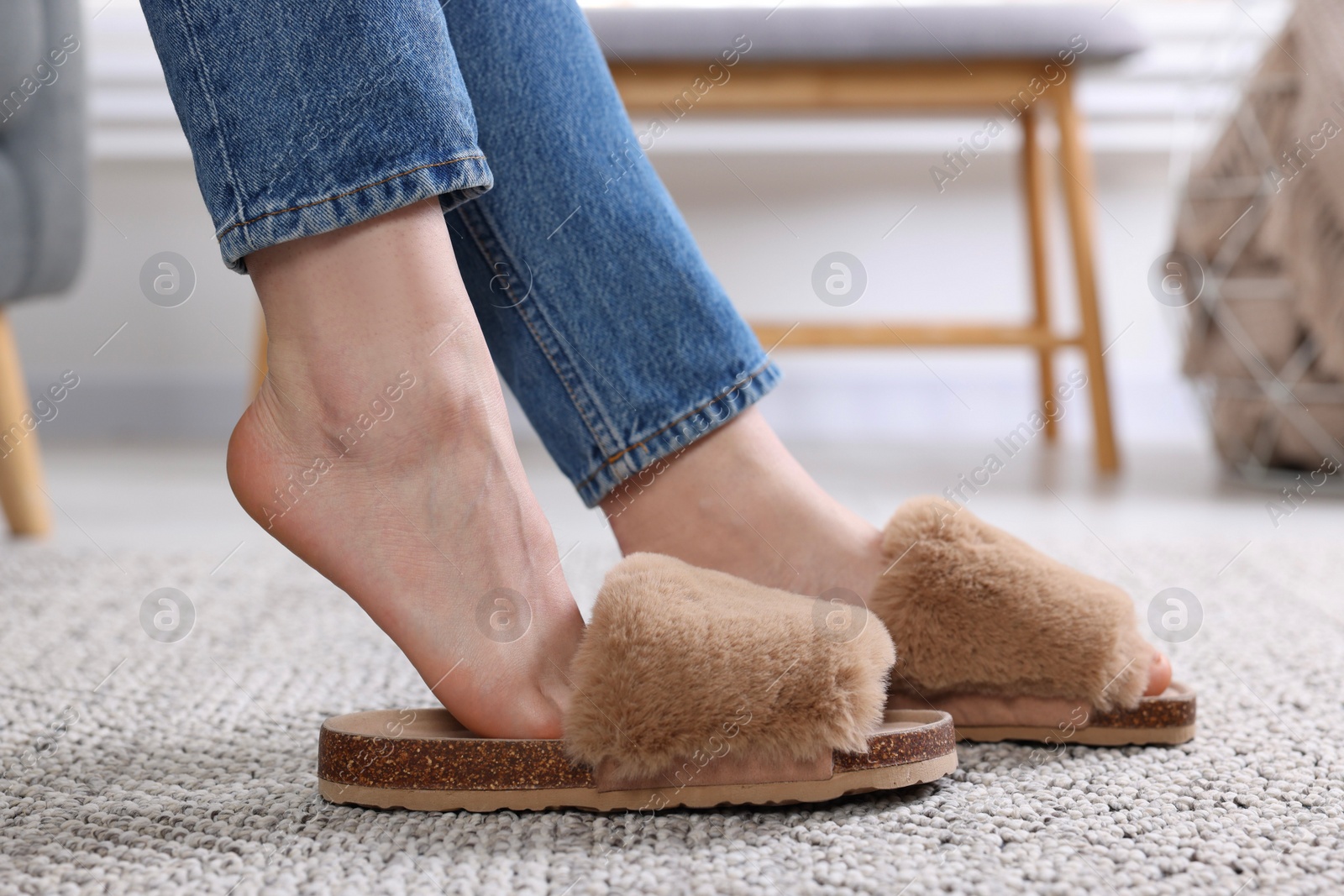 Photo of Woman in brown soft slippers at home, closeup
