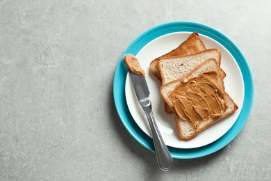 Plate with toast bread and peanut butter on table, top view