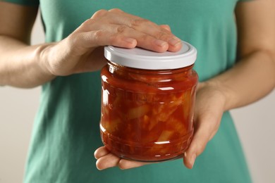 Woman holding jar of canned lecho, closeup