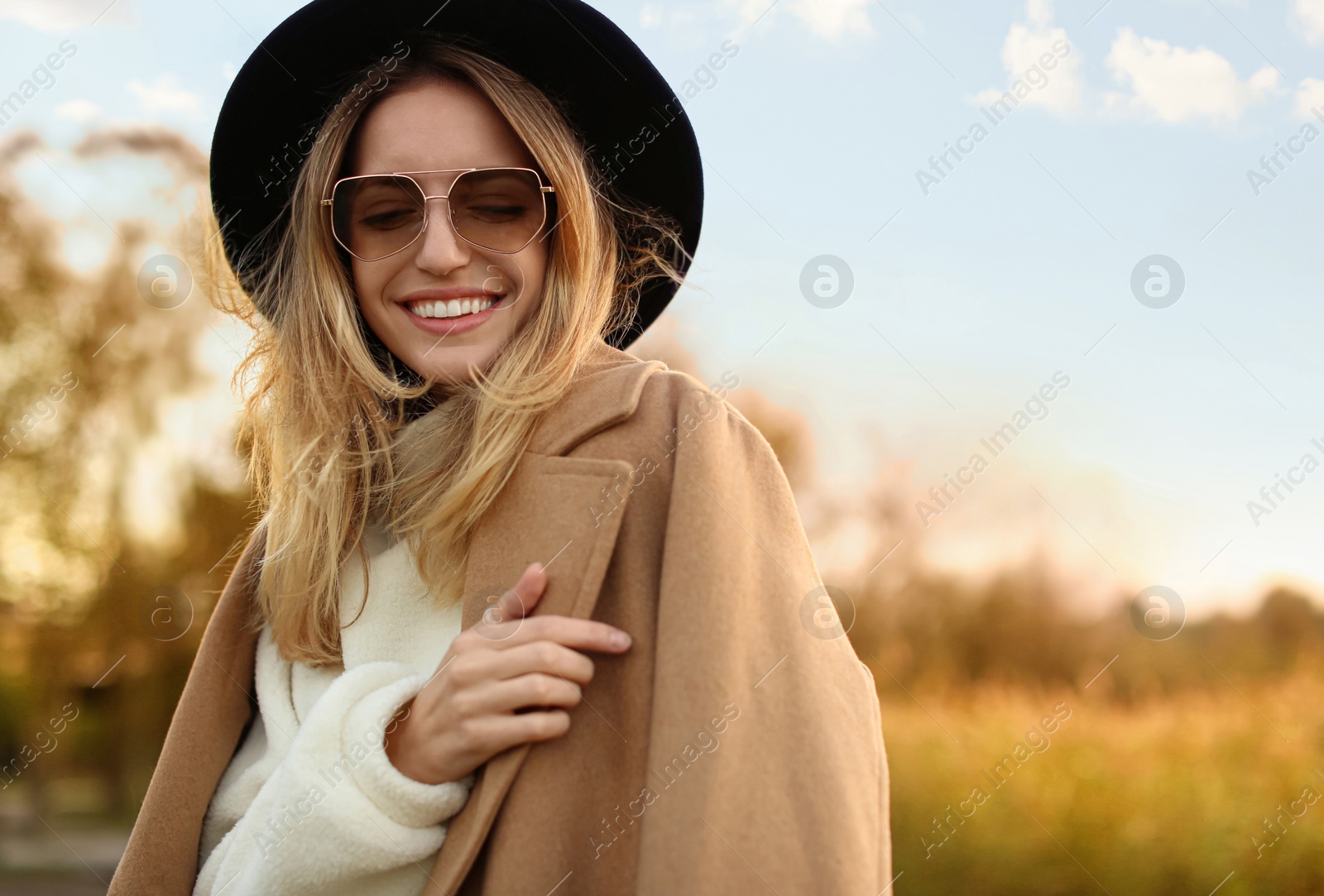 Photo of Beautiful young woman wearing stylish autumn clothes outdoors