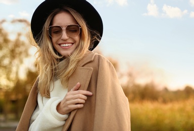 Beautiful young woman wearing stylish autumn clothes outdoors